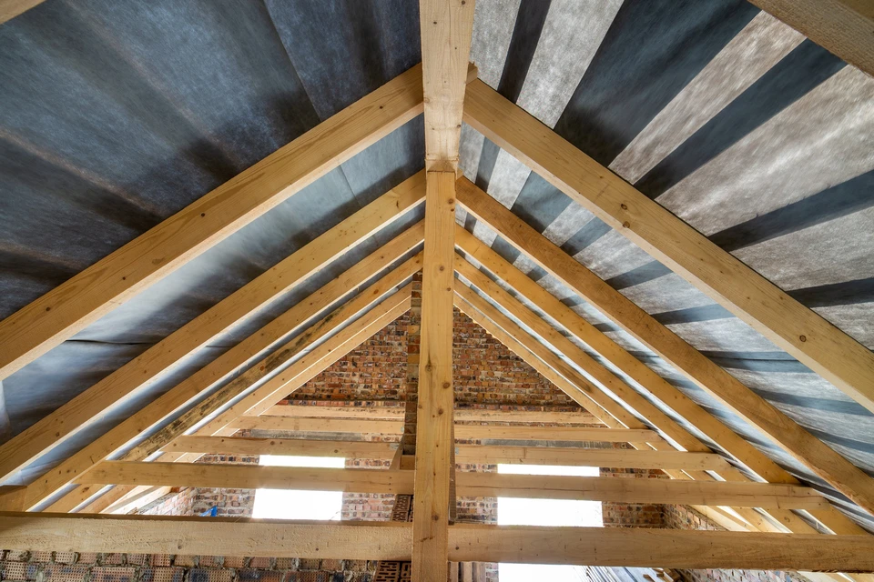 Intérieur de combles en cours de rénovation avec charpente traditionnelle apparente