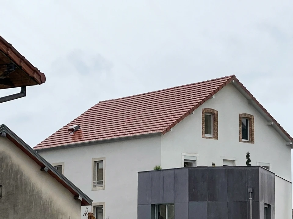 Chantier de construction en extérieur, maçon appliquant mortier avec truelle sur mur de briques rouges