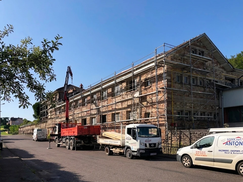 Chantier de construction extérieur avec maçon appliquant mortier sur briques alvéolaires rouges