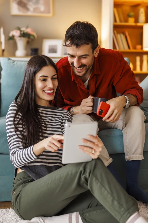 Entrepreneur en bâtiment discutant face à face avec un client propriétaire sur un chantier de rénovation de façade traditionnelle, pointant des détails d'enduit ou de maçonnerie, échangeant dans une ambiance de confiance et de proximité professionnelle sur le bâti ancien en restauration.